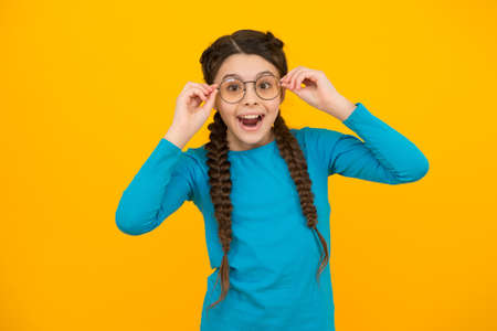 much better now. happy teenage girl in glasses. began to see better. kid fashion and beauty. small girl improve vision. childhood happiness. beautiful braided long hair. stylish braids and pigtailsの写真素材