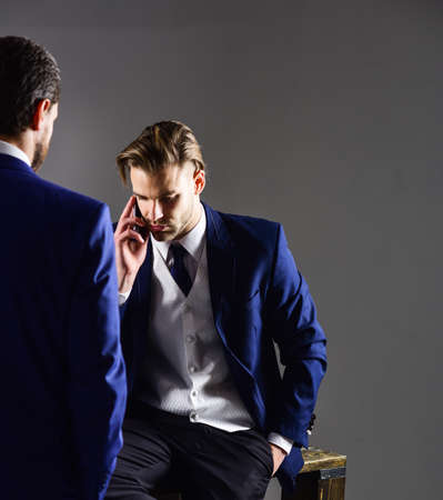 Man in classic suit or businessman with smartphone or mobile