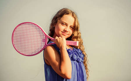 Active life. Child play tennis blue sky background. Sporty kid. Small girl with pink tennis racket. Summer leisure.の写真素材