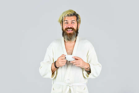 What a great morning. man drinks coffee in morning enjoying aroma. Happy hipster in bathrobe having...