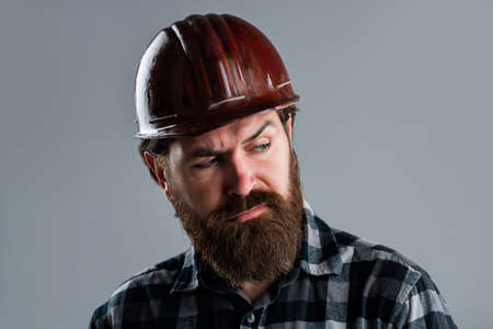 serious male worker wear hard hat. brutal builder in helmet. bearded repairman. confident...