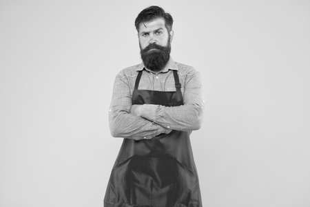 Restaurant cuisine. restaurant staff wanted. cooking is his hobby. bearded man in uniform. confident male housekeeper. Small business shop owner. mature shop assistant. professional chef in red apronの写真素材