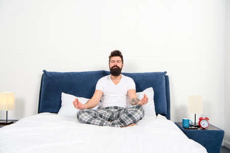 Man pajamas sit bed bedroom morning meditation, calm down concept
