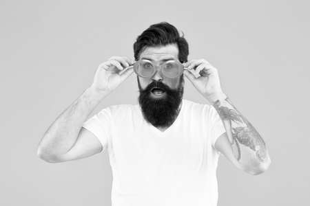 Wondering what is going on. Summer vacation. Ultraviolet protection concept. Handsome guy wear sunglasses. Hipster bearded man trendy sunglasses. Perfect vision. Eyes health. Fashionable sunglassesの写真素材
