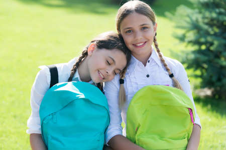 just relax. best school friends. going to school with fun. schoolgirls with backpack. teenage girls with backpacks walking in park. Back to school. Teen kids with backpack. concept of friendshipの写真素材
