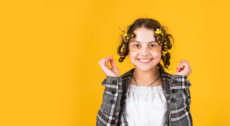 Child making hairstyle. little happy girl with curlers in hair. fabric mask under eyes for beauty....
