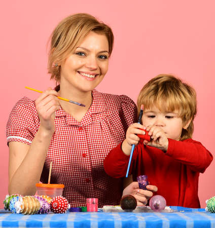 Mother and son painting eggs for Easterの写真素材
