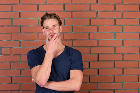 Macho with thoughtful and confident face holds hand hear chinの写真素材