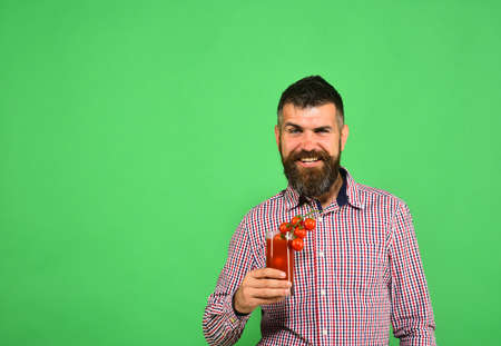Farmer with happy face offers fresh juice made of tomatoes.の写真素材