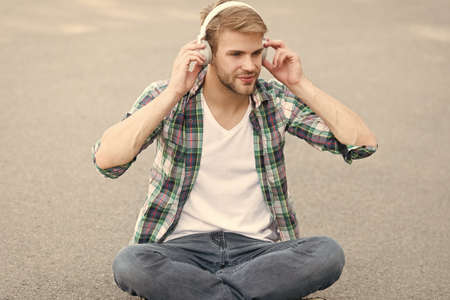 Online learning. Educational technology. E learning. Study anywhere. Audio book concept. Worldwide knowledge access. Audio library. Another way of learning. Man handsome college student headphonesの写真素材