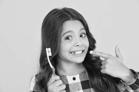 Tooth fairy concept. Loss baby teeth. Baby teeth have to fall out to make way for permanent teeth to grow. Girl showing her mouth without one tooth. Most kids are excited to feel a tooth wiggleの写真素材