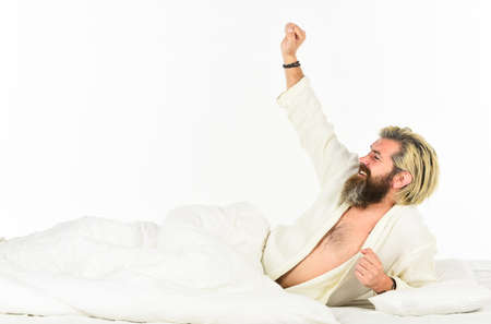 Enjoying time at home. mens health. man in bathrobe sleep in bed. tiredness and insomnia. brutal bearded hipster relax at home. cozy white bedroom. early wake up. lazy sunday. morning sex conceptの写真素材