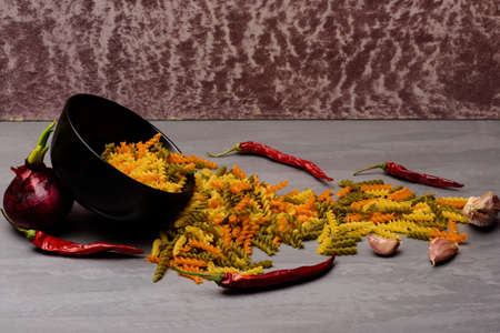 ingredients for cooking and italian pasta in black ceramic plateの写真素材