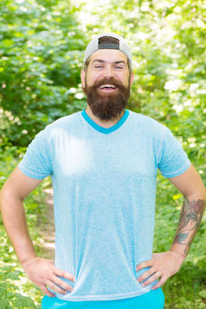 Pathways Into Nature. ready for camping. male bearded tourist wear cap. sport and fitness clothes. happy and handsome brutal man. brutal caucasian hipster with moustache. Bearded man with happy smileの写真素材