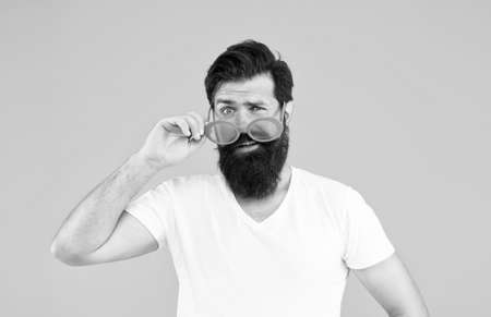 Accessory that suits your individual style. Hipster look through fancy glasses. Fashion party accessory. Wearing eye accessory with color filter. Bearded man with party look in trendy accessorの写真素材