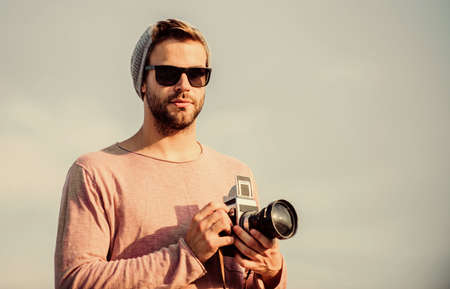Hipster reporter taking photo. Handsome photographer guy retro camera.