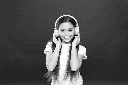 Music taste. Music plays an important part lives teenagers. Powerful effect music teenagers their emotions, perception of world. Girl listen music headphones on red background. Play list conceptの写真素材