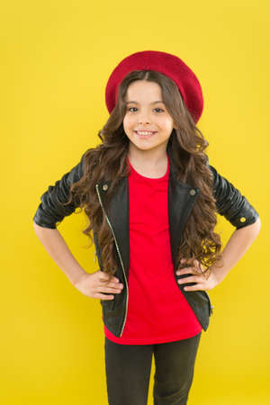 Simply the best in fashion. Happy cute child with fashion look. Small fashion model smiling on yellow background. Adorable little girl with long curly hair in modern fashion styleの写真素材