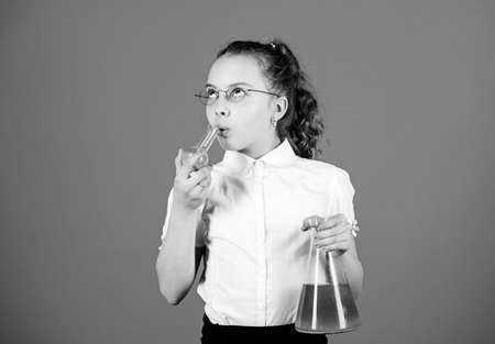 Safety measures. Knowledge and information. Experimenting a bit. Small kid study. Education concept. Chemistry fun. Basic knowledge. Knowledge day. Schoolgirl with chemical liquids. Education conceptの写真素材