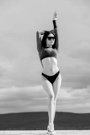 Booty woman wear bikini. Sporty female sexy body. Resort vacation relaxation. Sexy fashionable lady. Swimsuit fashion. Fashion trend. Modern girl. Girl attractive sexy body posing sky backgroundの写真素材