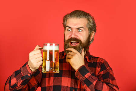 Beer pub. Bartender bar. Man hold mug of beer. Hipster at bar counter. Having fun. Alcohol beverage. Refresh your spirit. Modern hipster getting drunk. Welcome drink. Brutal bearded man drink beerの写真素材