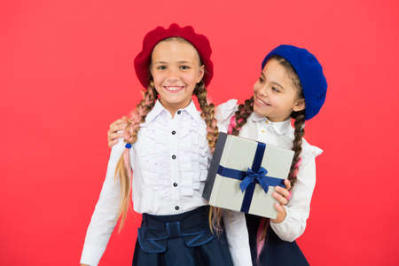 Little girl giving present to her friend. Happy children with small gift box wrapped with ribbon bow.の写真素材