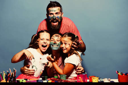 Parents and children painted with gouache on blue background. Girls, man and woman with cheerful...