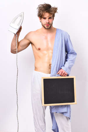 Man with muscular body hold iron Everyday life and housework.の写真素材