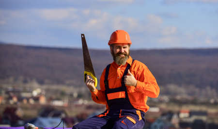 successful bearded man in hard hat. mature man builder use saw. professional repairman in helmet....
