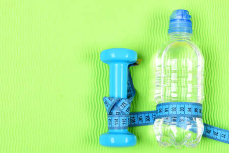 Fitness dumbbell, centimeter and bottle of water.の写真素材