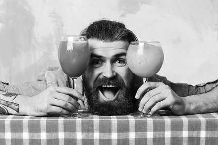 Brutal caucasian hipster with moustache between tropical alcoholic fresh cocktailsの写真素材