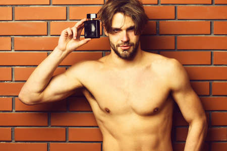 Caucasian bearded sexy macho man holding perfumeの写真素材