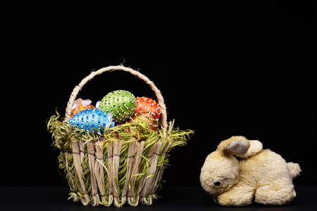 eggs decorated with bright color threads and beads in basketの写真素材