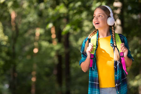 Happy child listen to headphones natural outdoors. Language learning courses.の写真素材