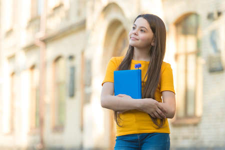 Little child girl back to school hold textbook, academic year conceptの写真素材