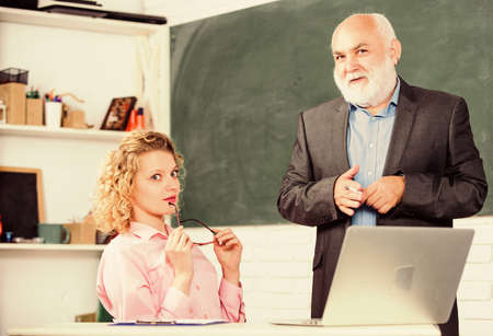 Work in education. Man mature school teacher and girl student with laptop. High school college...