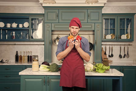 Pick fresh vegetables. Chef cooking vegetarian recipe. Man chef wear apron cooking kitchen. Man cook vegetarian recipe with fresh vegetables. Vegetables main ingredient. Recipe with fresh vegetablesの写真素材