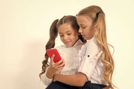 Educational application. Online entertainment concept. Schoolgirls cute pupils use smartphone check...