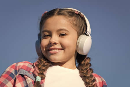 Beautiful girl with headphones. Young happy girl is listening to music. Stylish music lover. Happy smile on girl face. Enjoying songの写真素材