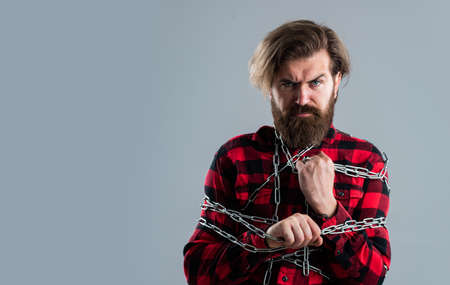 Very tight. conceptual symbol of freedom. male fashion. strong man with chains. problem solving. man in captivity. concept applicable for business. man tearing heavy steel chain by hands. copy spaceの写真素材