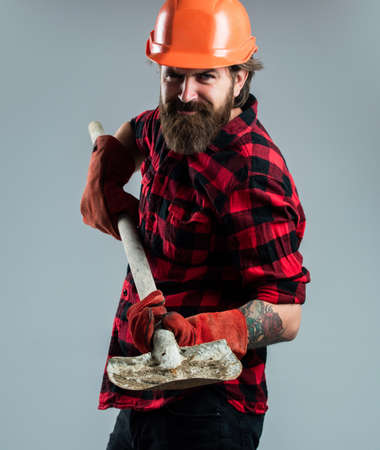 Ready to work. construction worker wear safety helmet. wearing safety gear. supervisor at construction site. confident serviceman. brutal hipster man. man in hard hat. engineer use shovel in glovesの写真素材