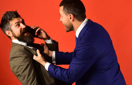 Businessman with surprised face holds mobile phone