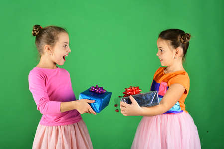 Children open gifts for Christmas. Sisters with wrapped gift boxesの写真素材
