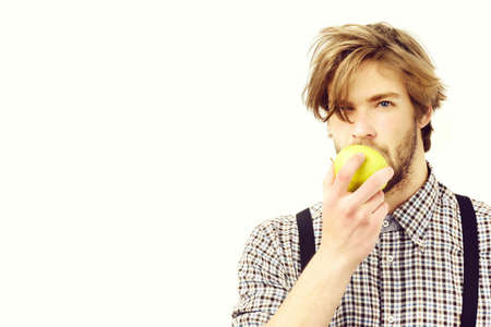 Man with beard and stylish hairdo holds green apple