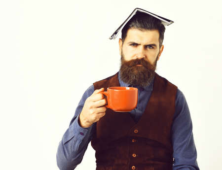 bearded man holding notepad, cup of tea with serious faceの写真素材