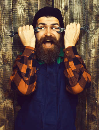 Bearded brutal caucasian mechanic holding metallic wrenchesの写真素材