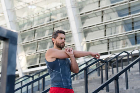 Man stretching. Keeping those muscles flexible. Training on fresh air. Warming up his muscles....