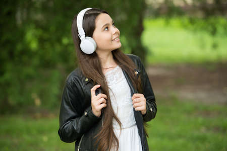 Hipster girl listening music modern headphones nature background, mood and emotions conceptの写真素材
