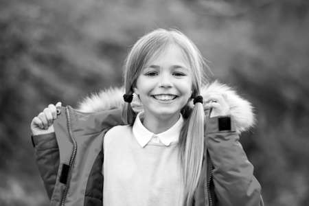 Girl with blond hair ponytail smile on natural landscapeの写真素材