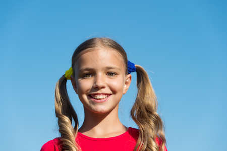 Cheerful little girl adorable ponytails hairstyle outdoors, true happiness conceptの写真素材